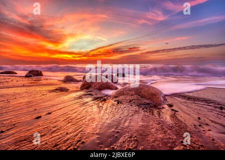 Ocean Landscape Sunset ist Ein farbenfroher Sonnenuntergang mit Einer sanften Welle, die im hochauflösenden Bildformat an die Küste rollte Stockfoto