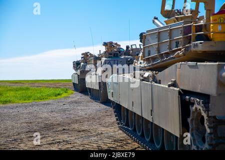 Drei M1 Abrams aus dem 1. Combined Arms Battalion, 63. Armor Regiment, 2. Armed Brigade Combat Team, 1. Infantry Division, bevor sie den Douthit Gunnery Complex und den Digital Multipurpose Range Complex in Fort Riley, Kansas, verlassen, 2. Juni 2022. Nach erfolgreicher Qualifikation am Vortag, Mitglieder der 1. Mrd. 63.. Rüstung Regt. Line up ihrer jeweiligen Tanks für die endgültige Freigabe vor dem Verlassen des Bereichs. (USA Army Photo von PFC. Kenneth Barnett, 19. Public Affairs Detachment) Stockfoto