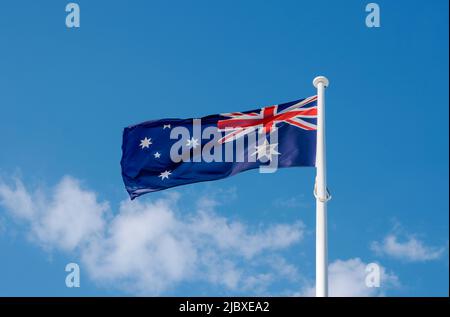 Nahaufnahme der australischen Flagge, die in der Brise gegen den blauen Himmel flattern Stockfoto