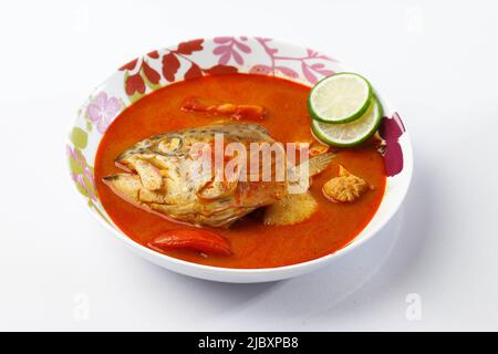 Köstlicher King Fish Head Sweet and Sour Curry, zubereitet mit Tomaten, Limette, Chili und anderen traditionellen Gewürzen. Beliebt als Gulai Kepala Ikan Stockfoto