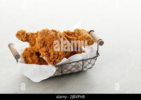 Paniertes knuspriges gebratenes Kentucky Chicken Drumctick im Drahtkorb, Copy Space for Text Stockfoto