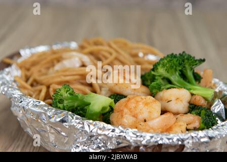 Köstlicher Korb mit gegrilltem Shimp und Chow-Mein-Nudeln mit Gemüse für eine leckere Mahlzeit mit Meeresfrüchten. Stockfoto