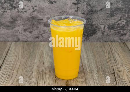 Leckerer Mango-Milchshake in einer hohen Tasse und eiskalt für durstigen Appetit. Stockfoto