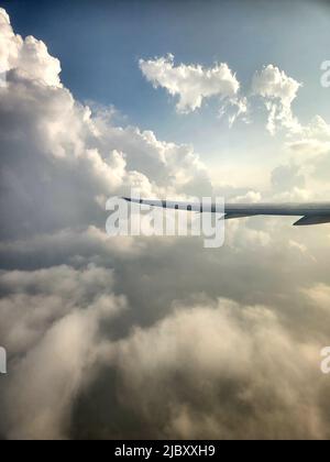 Blick aus einem Flugzeugfenster auf dramatische Wolken über Nepal Stockfoto