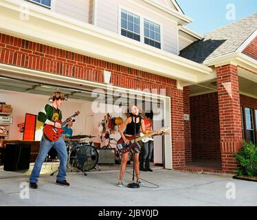 Gruppe von Freunden in der Garage Band üben in der Auffahrt vor dem Haus Stockfoto