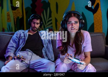 Freunde spielen nachts Videospiele zu Hause auf der Couch Stockfoto