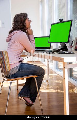 Lächelnde junge Frau bei einem Videoanruf im Heimbüro. Stockfoto