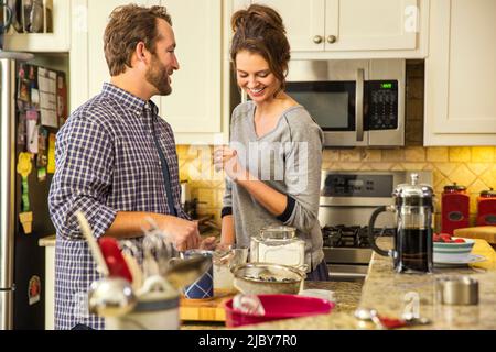 Junges Paar mit Spaß in der Küche machen Heidelbeer Pfannkuchen Stockfoto