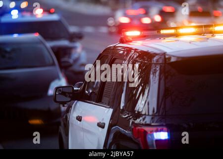 La Habra, Kalifornien / USA - 27. April 2022: Polizeieinheiten ziehen auf einer Stadtstraße über ein Auto. Stockfoto