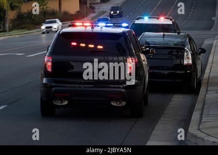 La Habra, Kalifornien / USA - 27. April 2022: Polizeieinheiten ziehen auf einer Stadtstraße über ein Auto. Stockfoto