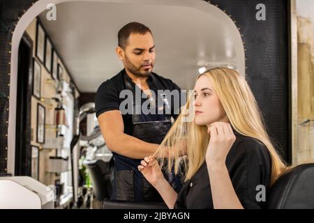 Stylistin berät sich vor dem Friseurtermin im Boutique-Salon mit einer jungen Frau Stockfoto