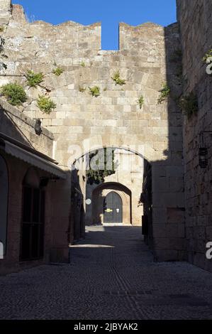 Gepflasterte Gasse mit steinernen Torbögen, in der Altstadt von Rhodos, Insel Rhodos, Griechenland, Dodekanes. Aufgenommen am 2022. Mai. Frühling Stockfoto