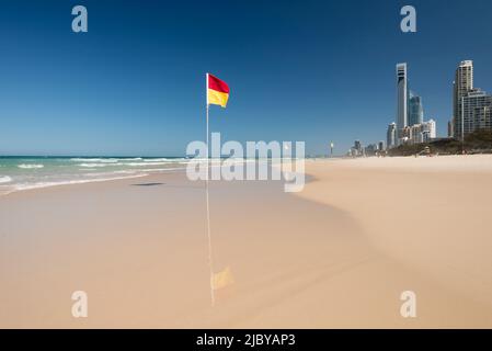 Eingefurste Rettungsflagge am leeren Strand - Gold Coast Stockfoto