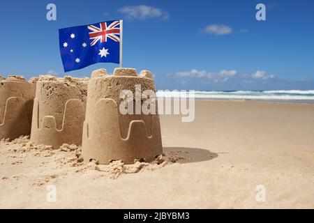 Australische Flagge auf Gruppe von drei Sandburgen am Strand Stockfoto