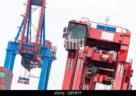 Hamburg, Deutschland. 08.. Juni 2022. Ein Sattelträger steht mit unbesetzter Kabine vor einem angehobenen Container-Portalkran an einem Containerterminal in Waltershof. Zum ersten Mal seit Jahrzehnten droht ein Warnstreik von Hafenarbeitern an den großen deutschen Seehäfen, die Schiffe zum Stillstand zu bringen. Quelle: Jonas Walzberg/dpa/Alamy Live News Stockfoto