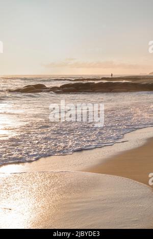 Einköpfige Person am felsigen Maroochydore Strand am frühen Morgen Stockfoto