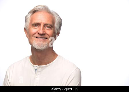 Porträt eines weißen Mannes mittleren Alters mit grauen Haaren, der mit einem Lächeln auf die Kamera blickt Stockfoto