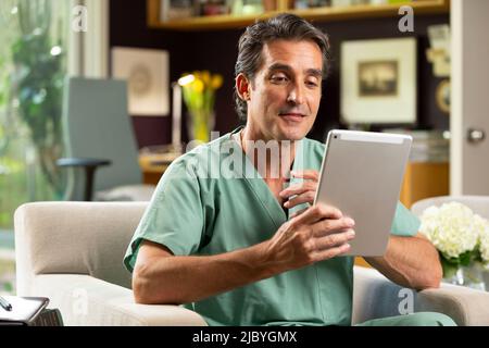 Hispanischer Arzt mit Telemedizin aus seinem Heimbüro, der per Videoanruf auf dem Tablet mit dem Patienten spricht Stockfoto