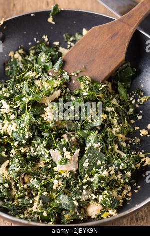 Gekochte Moringa oder Drumstick Blätter Gericht in einer Pfanne mit Holzspatel, gemischt mit geriebener Kokosnuss und mit Öl angelassen, vegetarische gesunde Gericht in der Nähe Stockfoto