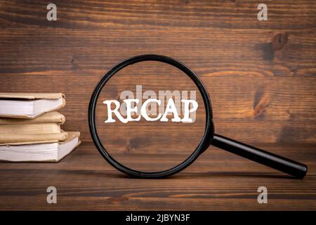 Zusammenfassung des Konzepts. Vergrößerungsglas und Bücher auf einem Holzhintergrund. Stockfoto