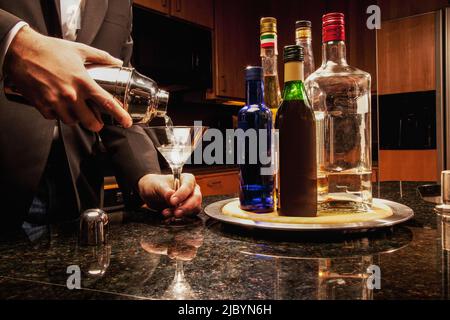 Hispanic Mann Gießen Martini in Küche Stockfoto