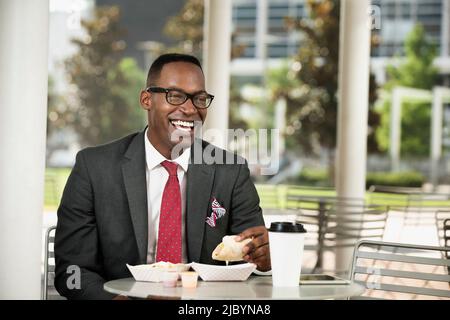 Schwarze Geschäftsmann Essen im café Stockfoto