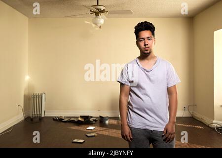 Mann in kargen Wohnung Stockfoto