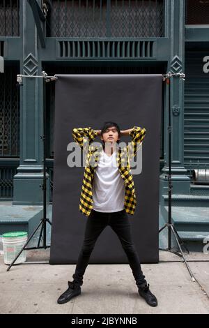 Asiatischer Mann posiert für Foto-Shooting auf Stadt Bürgersteig Stockfoto