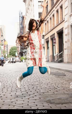 Japanische Frau springen vor Freude auf Stadtstraße Stockfoto