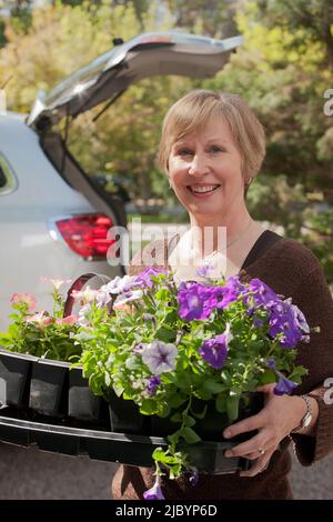 Kaukasische Frau mit Tablett von Blumen Stockfoto