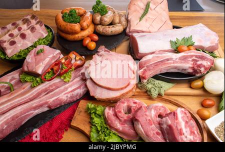 Verschiedene schöne rohe Schweinestücke, darunter Hacken, Wurst, Rippchen, Steak Stockfoto