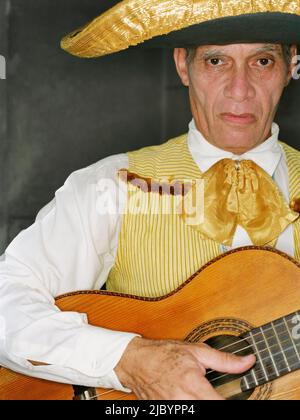 Älterer Mann in traditioneller Kleidung, der Gitarre spielt Stockfoto