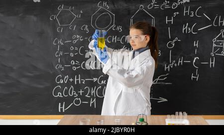 Studentin Wissenschaftler untersucht Testflasche mit chemischem Reagenz. Schülerin macht Experiment in Chemie-Klasse. Forschung und Bildung in der Schule Stockfoto