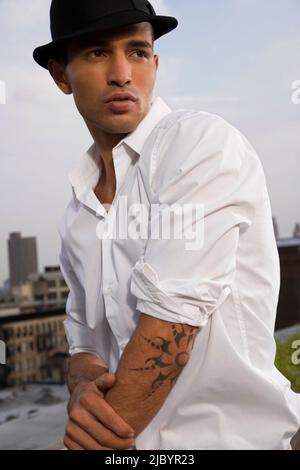 Hispanic Mann mit Tattoo tragen fedora Stockfoto