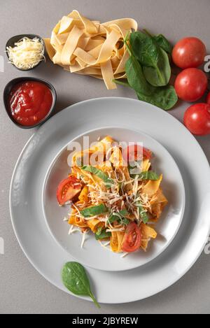 Italienische Pasta auf grauem Hintergrund mit Zutaten Stockfoto