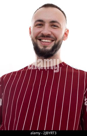 Nahaufnahme des vertikalen Bildes des unrasierten menschlichen Gesichts, das posiert und die Kamera anschaut. Männlich mit schönem Lächeln. Zahnaufhellung Stockfoto