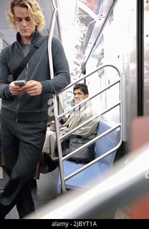 Kaukasische Geschäftsmann SMS auf Handy in u-Bahn Stockfoto