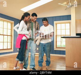 Paar mit Arbeiter reden, Umgestaltung Raumes Stockfoto