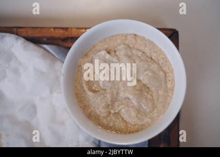 Nahaufnahme des beliebten Pita-Brotes und Hummus in einer weißen Schüssel in einem Holztablett. Flat Lay. Selektiver Fokus. Stockfoto