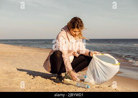 Aktivistin und Assistentin putzt Strand von Unterwassermüll, Meer, Meer mit Plastikmüll. Umweltverschmutzung Stockfoto