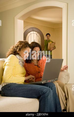 Frauen mit Laptop im Wohnzimmer Stockfoto