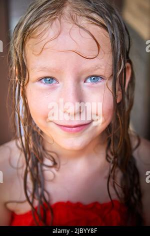 Happy lustige kleine blone Mädchen mit nassem Haar nach Regen in einem Sommer oder Frühlingstag Stockfoto