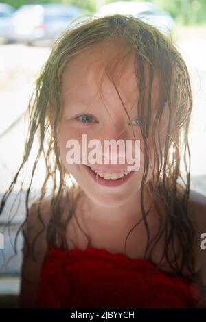 Happy lustige kleine blone Mädchen mit nassem Haar nach Regen in einem Sommer oder Frühlingstag Stockfoto