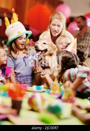 Gruppe von Kindern auf Geburtstagsparty mit Hund Stockfoto