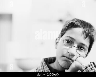 Close up Portrait of Hispanic junge gelehnt Kinn in die hand Stockfoto