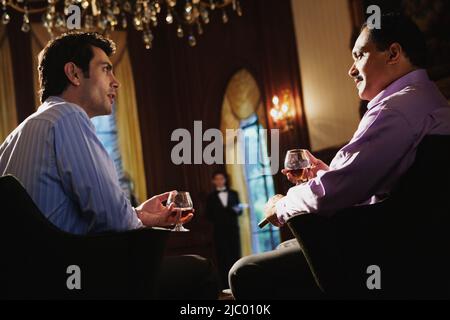 Zwei Männer trinken und reden Stockfoto