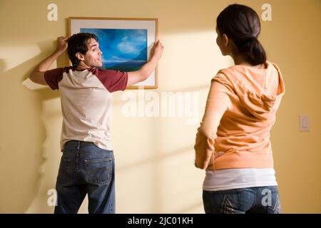 Hispanische paar Gemälde an der Wand hängen Stockfoto