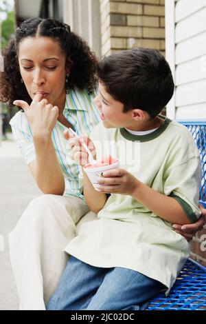 Mutter und Sohn gemeinsam Eis essen Stockfoto