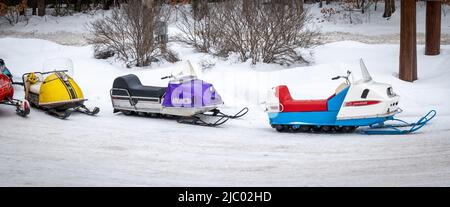 NISSWO, MN - 21 JAN 2022: Alte McCulloch, Viking und Polaris Charger Schneemobile sitzen im Winter auf einem schneebedeckten Parkplatz. 1960s and1970s Jahrgangswein Stockfoto