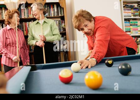 Ältere Frau schießen pool Stockfoto